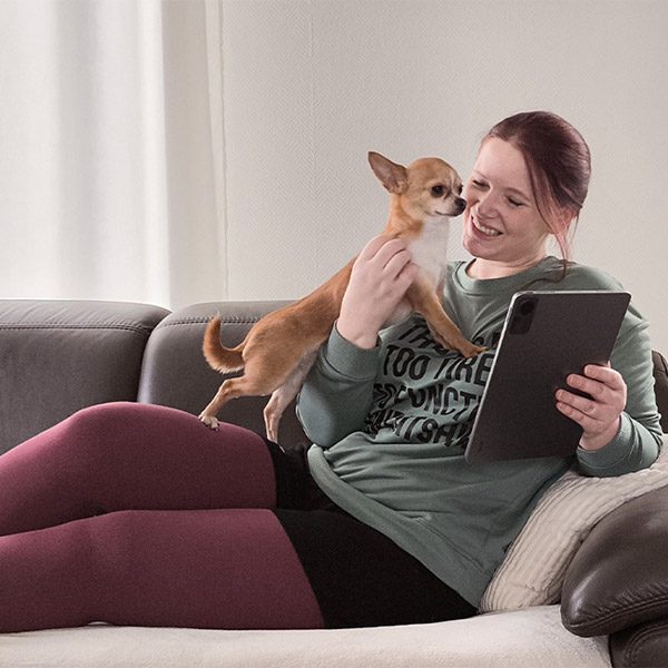 Botschafterin Kathi kuschelt mit ihrem Hund auf dem Sofa