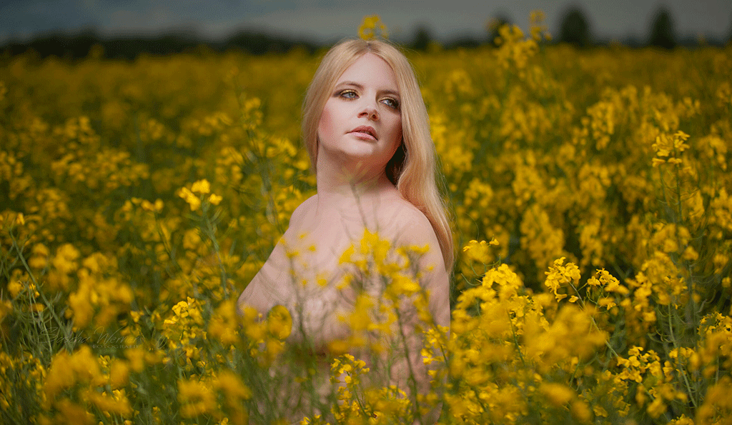 Aktfoto im Feld mit gelben Blüten