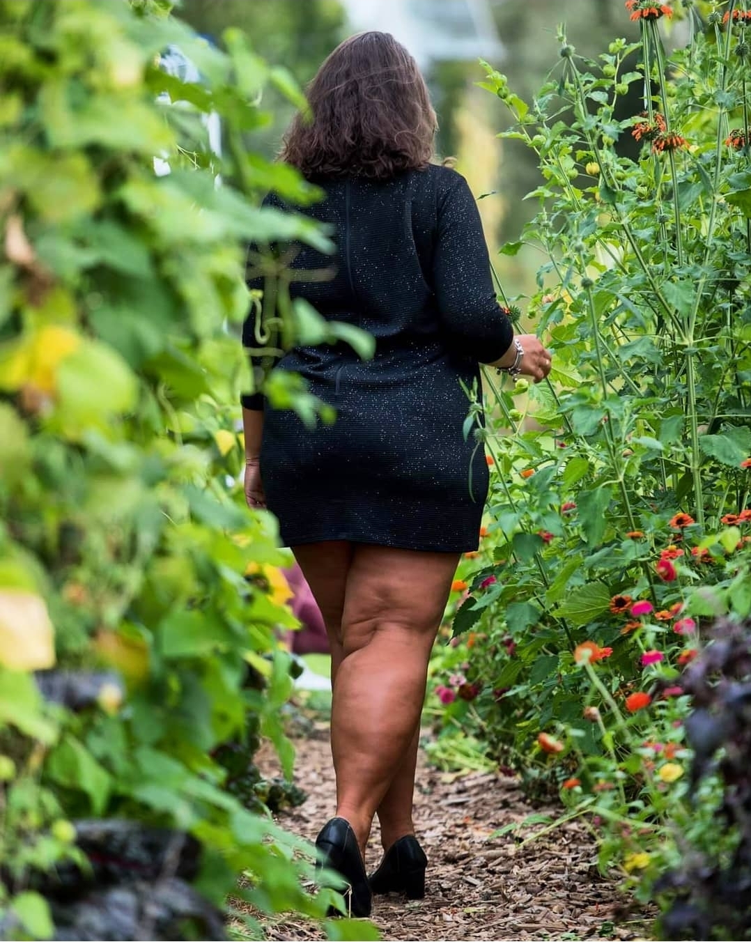 Bloggerin Kathi geht durch ein Blumenfeld und zeigt ihre nackten Bein