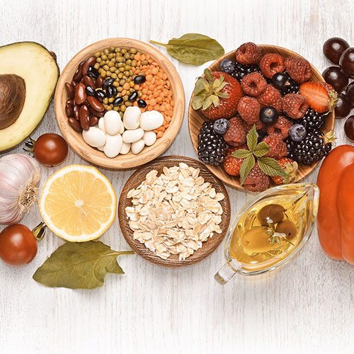 Schalen mit verschiedenen Lebensmitteln, wie Beeren, Avocado und Haferflocken