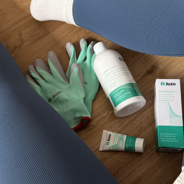 Jenny mit blauer Kompression und verschiedenen Produkten von Juzo