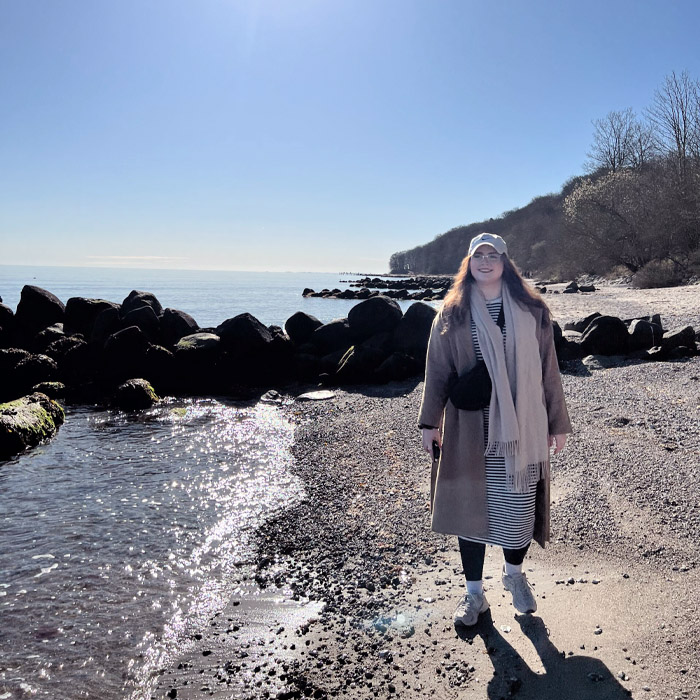 Jenny am Strand und schaut in die Kamera
